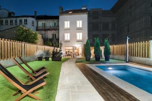 a backyard with two chairs and a swimming pool at Hotel Pousada Real in Caldas de Reis