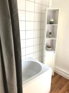 een badkamer met een wit bad en een plank bij Castleton townhouse in Belfast