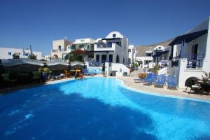 a large blue swimming pool in front of some buildings at Samson΄s Village in Perissa