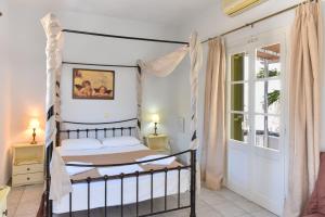 um quarto com uma cama de dossel e uma janela em Giannakas Studios em Platis Gialos, Sifnos
