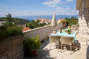 una mesa y sillas en un balcón con vistas en Apartment Vrbnik 8, en Vrbnik