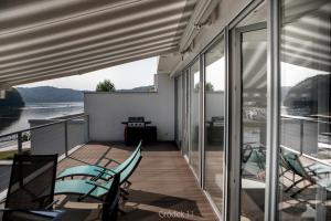 a balcony with chairs and a view of the water at Apartment Słoneczny Gródek 11 in Gródek Nad Dunajcem