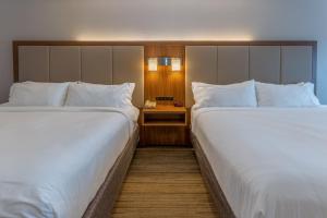 duas camas sentadas uma ao lado da outra num quarto de hotel em Holiday Inn Express - Indianapolis - Southeast, an IHG Hotel em Indianápolis