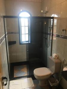 a bathroom with a toilet and a shower with a window at Abigail Condé in Ouro Preto