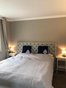 a bedroom with a large white bed with two lamps at Strandgut 63 in Scharbeutz +37 photos