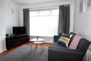 a living room with a couch and a window at Carwood House in Newtownabbey