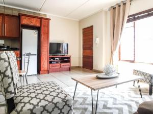 een woonkamer met een tafel en een keuken bij Alimama Spaces: Chelsea Pad in Johannesburg