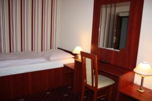 A bed or beds in a room at Hotel Hynek