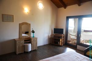 a bedroom with a bed and a mirror and a television at Ribarica GO green in Ribarica