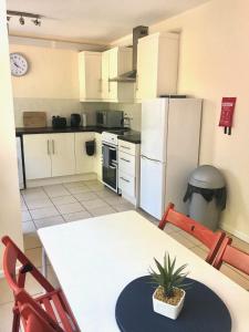 a kitchen with a table and a white refrigerator at Carwood House in Newtownabbey