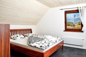 een slaapkamer met een bed en een raam bij Holiday House Sabala 2 in Stará Lesná