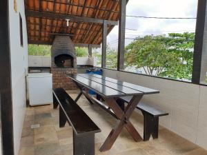 a picnic table in a kitchen with a brick oven at Cantinho do Village in São Pedro da Aldeia