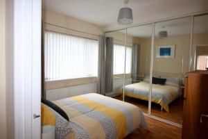 a bedroom with two beds and a large mirror at Carwood House in Newtownabbey