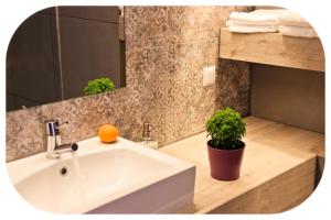 a bathroom with a sink and a potted plant at Altanahouse in Parga +9 photos