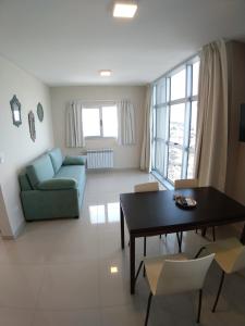 Una sala de estar con una mesa y un sofá azul. en BR, en Bahía Blanca