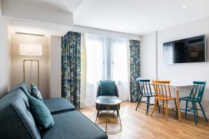 CADET Residence في باريس: غرفة معيشة مع أريكة وكراسي وطاولة