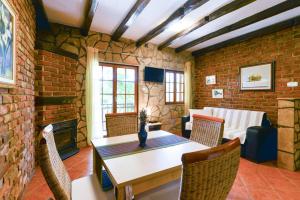 salon ze stołem i ceglaną ścianą w obiekcie Villa Steffany Apartments w mieście Kolan