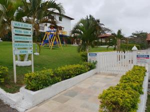 a sign in a park with a playground in the background at Cantinho do Village in São Pedro da Aldeia