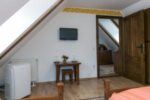 a room with a table and a tv and a door at Casa Richter- Check-in Independent in Sighişoara