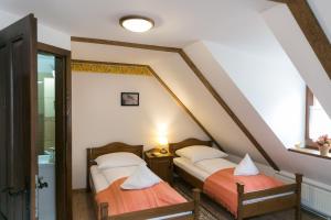 two twin beds in a attic room with a window at Casa Richter- Check-in Independent in Sighişoara