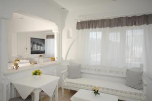 a white room with white chairs and tables and a mirror at Hotel Milena in Mýkonos City