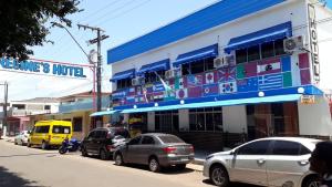 a street with cars parked in front of a building at Regine's Hotel in Itaquatiara