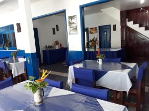 a dining room with two tables and blue chairs at Regine's Hotel in Itaquatiara