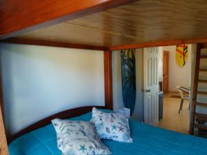 a bed with blue sheets and pillows in a room at Casa Estela del Mar in Pelluhue