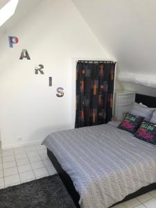 a bedroom with a bed and a curtain with letters on the wall at Sleep in Paris - Chessy in Chessy