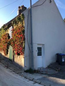 a white building with ivy growing on the side of it at Sleep in Paris - Chessy in Chessy