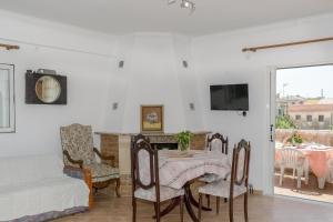 a living room with a table and chairs and a tv at Modern flat with beautiful views in south of Corfu in Lefkímmi