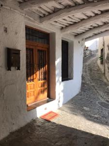 una puerta en el lateral de un edificio con una calle en CASA M'GUIRE, en Pampaneira
