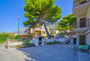 a tree in the middle of a street with buildings at Apartments Marinko in Makarska