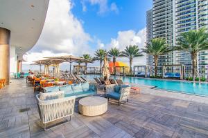 a pool with chairs and tables and a building at LYFE 4111 S Ocean dr in Hollywood