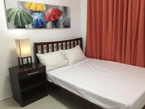 sypialnia z łóżkiem i stolikiem nocnym z parasolami w obiekcie Bords Sweet Home w mieście Davao