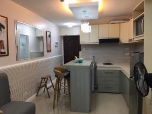 a kitchen with white cabinets and a counter top at Bords Sweet Home in Davao City