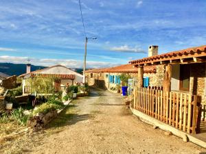 a dirt road between two houses with a fence at Mosteirinho in Negreda
