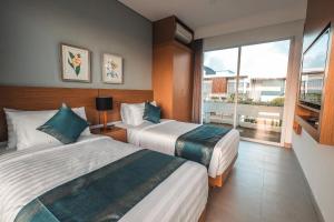 une chambre d'hôtel avec deux lits et une grande fenêtre dans l'établissement Aurelia Residence, à Uluwatu 81 autres photos