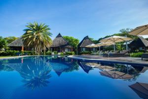 una piscina in un resort con sedie e ombrelloni di Yatule Resort & Spa a Natadola