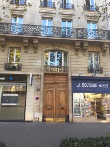a building with a wooden door in front of a store at cosy rare 2 bedroom apartment around a private garden in Neuilly-sur-Seine