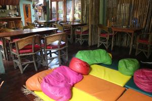 a colorful bean bag couch in a restaurant with tables and chairs at Hostal Mamacucha in Montañita