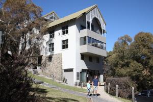 a man and a child walking in front of a building at Boali Lodge Thredbo in Thredbo