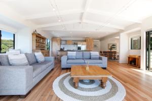 uma sala de estar com um sofá e uma mesa em Beachfront Enclosure Bay - Waiheke Unlimited em Oneroa