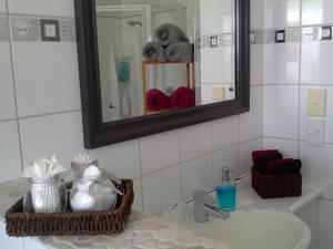 a bathroom with a sink and a mirror at The Little Gem in Waitara