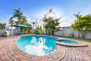 a swimming pool with a brick walkway around it at Rockhampton Riverside Central Hotel Official in Rockhampton