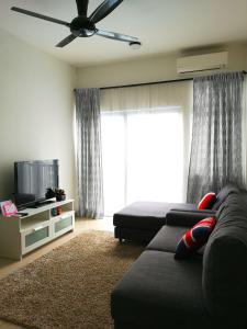 Meridin Bayvue Serviced Apt في Kampong Kuala Masai: غرفة معيشة مع أريكة وتلفزيون بشاشة مسطحة