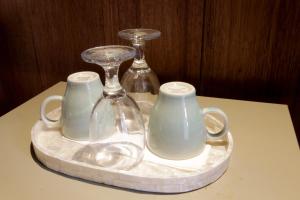 a tray with three glass vases and glasses on a table at Jungle Joglo in Tampaksiring +82 photos