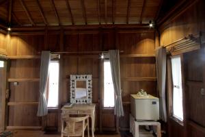 a bathroom with wooden walls and a sink and a mirror at Jungle Joglo in Tampaksiring