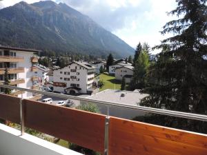 a balcony with a view of a town and a mountain at Astoria (175 Cl) in Lenzerheide