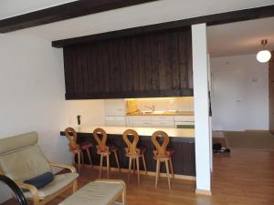 eine Küche mit einer Reihe von Stühlen und einer Theke in der Unterkunft Astoria (175 Cl) in Lenzerheide